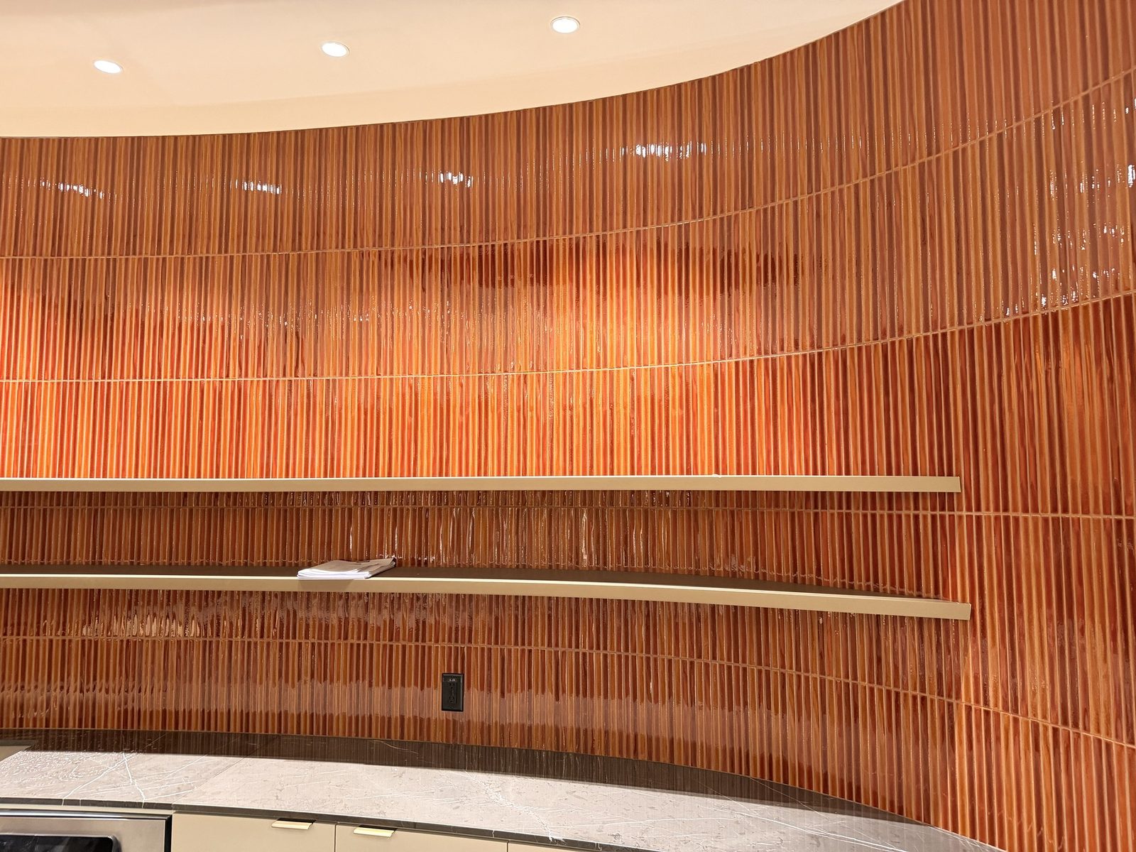 Curved terracotta glazed tile feature wall with custom millwork