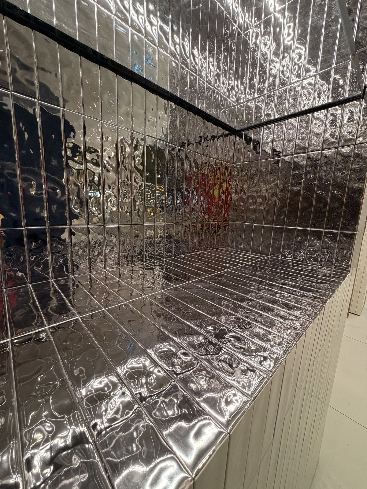 Vertical metallic tile wrapping a custom display ledge