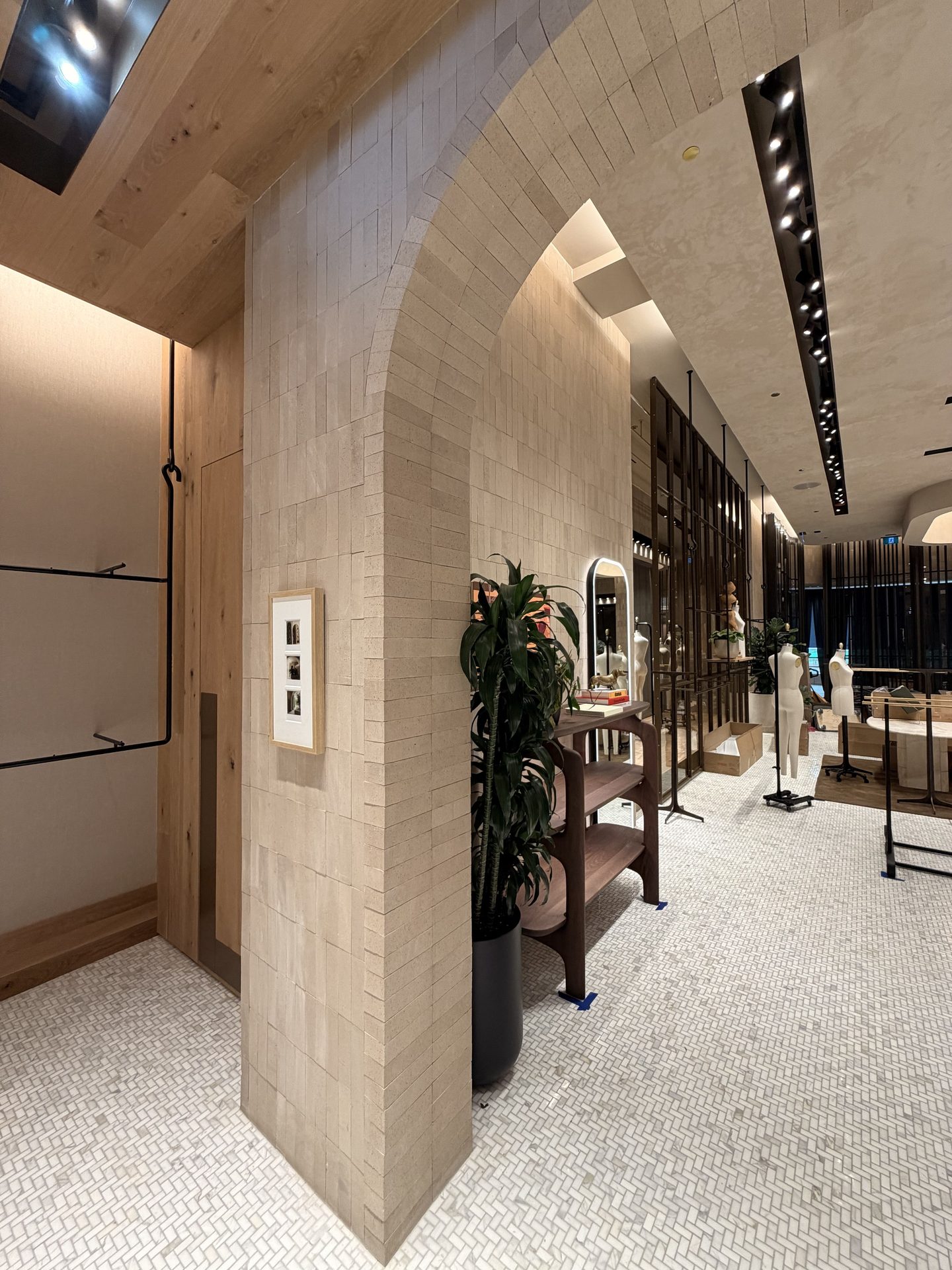 Herringbone mosaic floor and tiled arch in a finished luxury retail interior